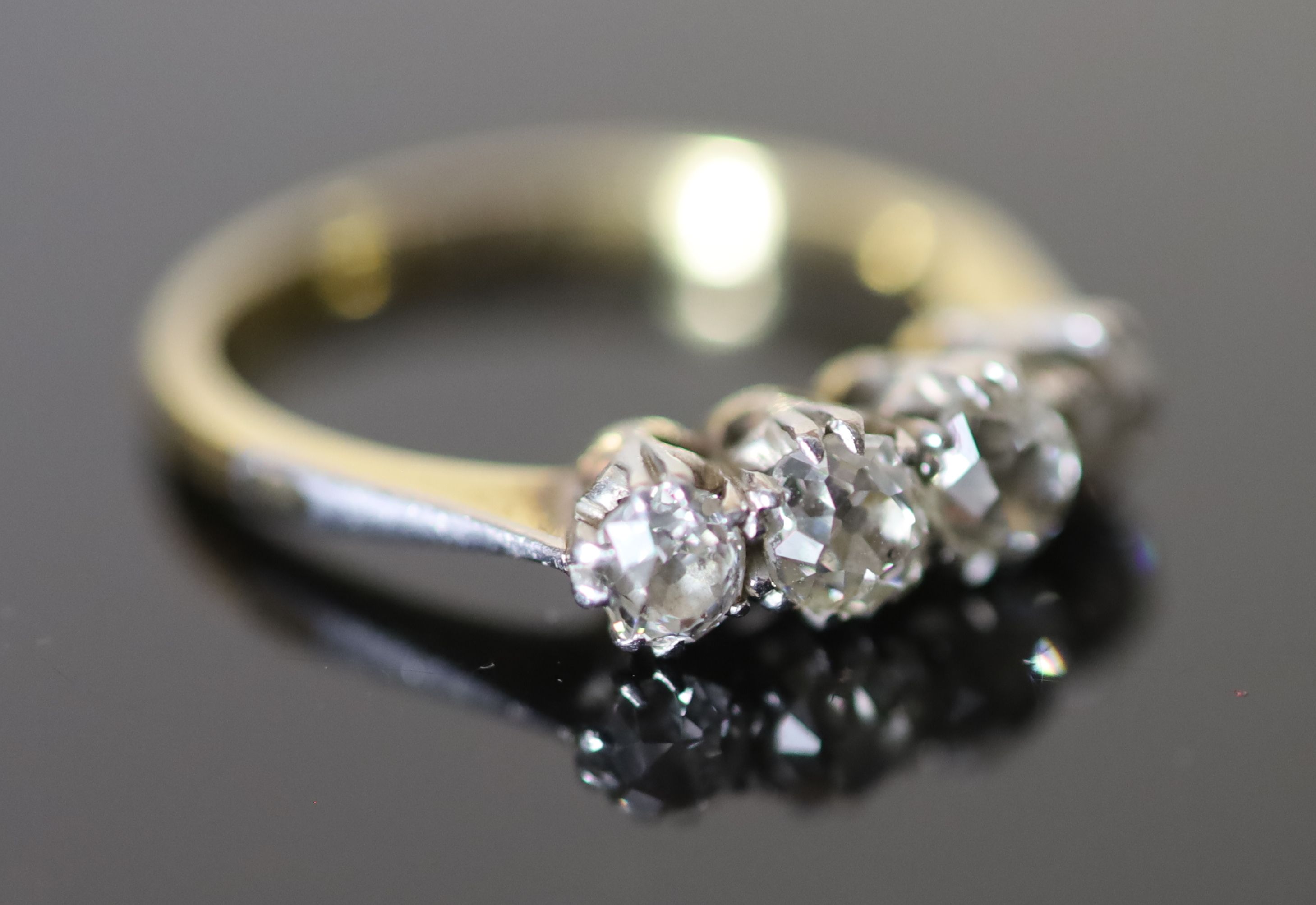 An early 20th century 18ct gold, platinum and graduated four stone diamond ring,